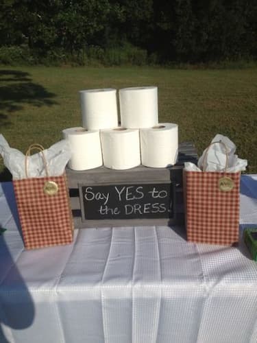 Join in on the Say Yes To The Dress fun. Say Yes to the Dress Bridal Shower Game: Table with toilet tissue and prizes needed for game.