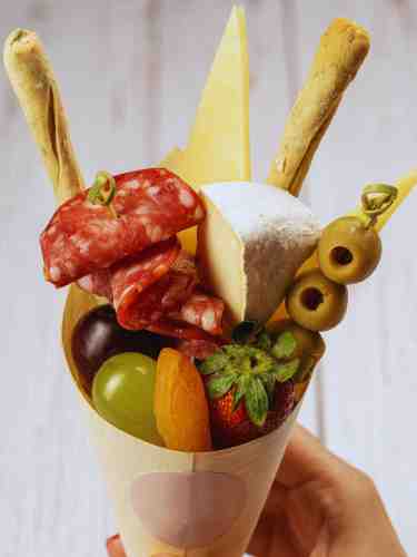 Charcuterie Cones: Offer A Single, Handheld Serving At Your Next Party Charcuterie cones filled with meats, cheeses, crackers, and fresh fruits.