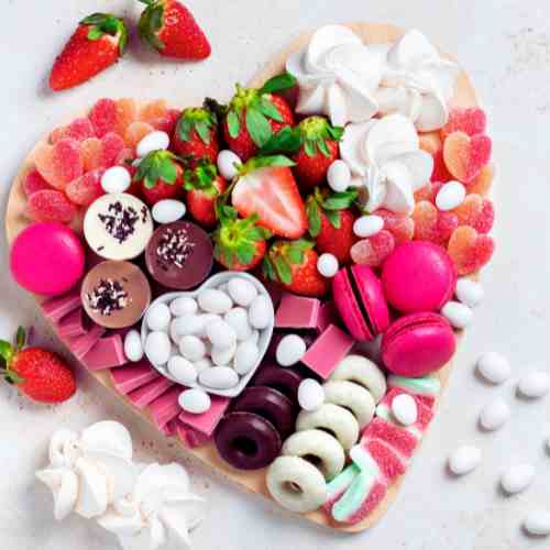 Valentine's Day Charcuterie Board: How Sweet It Is! Valentine's Day charcuterie board featuring a variety of pink, white, and red goodies.