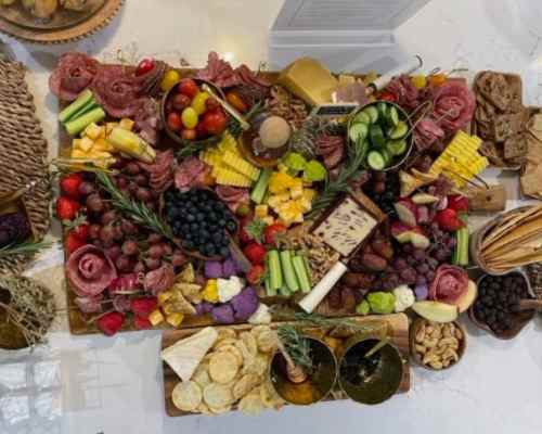 Large Charcuterie Board: Think Big! A large charcuterie board filled with a variety of cheeses, meats, fruits, and dips.