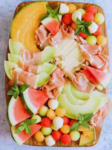 Make Your Fruit And Cheese Charcuterie Board Enticing With A Variety Of Melons Served In Different Ways Colorful fruit and cheese charcuterie board featuring a variety of melons.