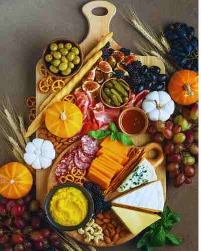 Autumn-Inspired Charcuterie Board Ideas For Fall Entertaining A rustic charcuterie board for fall featuring seasonal fruits, nuts, and cheeses.