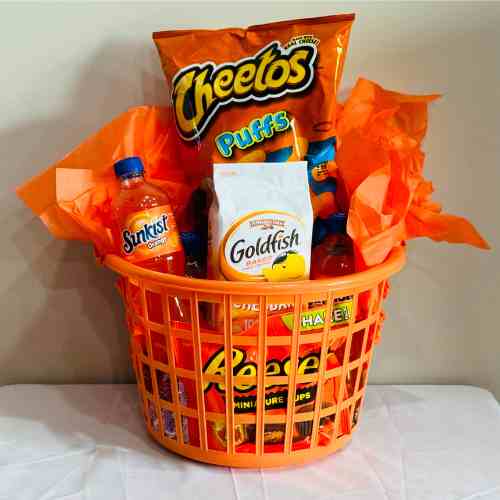 Pick An Orange Basket For Color Party And Fill With Orange Packaged Treats Orange basket for color party filled with sweet and savory treats packaged in orange.