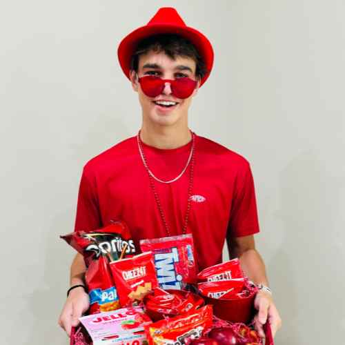 Red Basket For Color Party: See Red In A Variety Of Ways Red items for Color Party creatively arranged in a basket carried by a guest dressed in red.