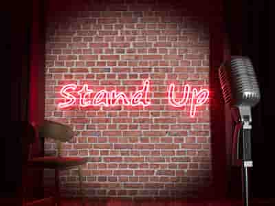Stand Up sign on a red brick wall.