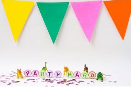 Celebrate with Dinosaur Birthday Decorations! Toy Dinosaurs and Confetti Scattered Around a Party Hard Sign