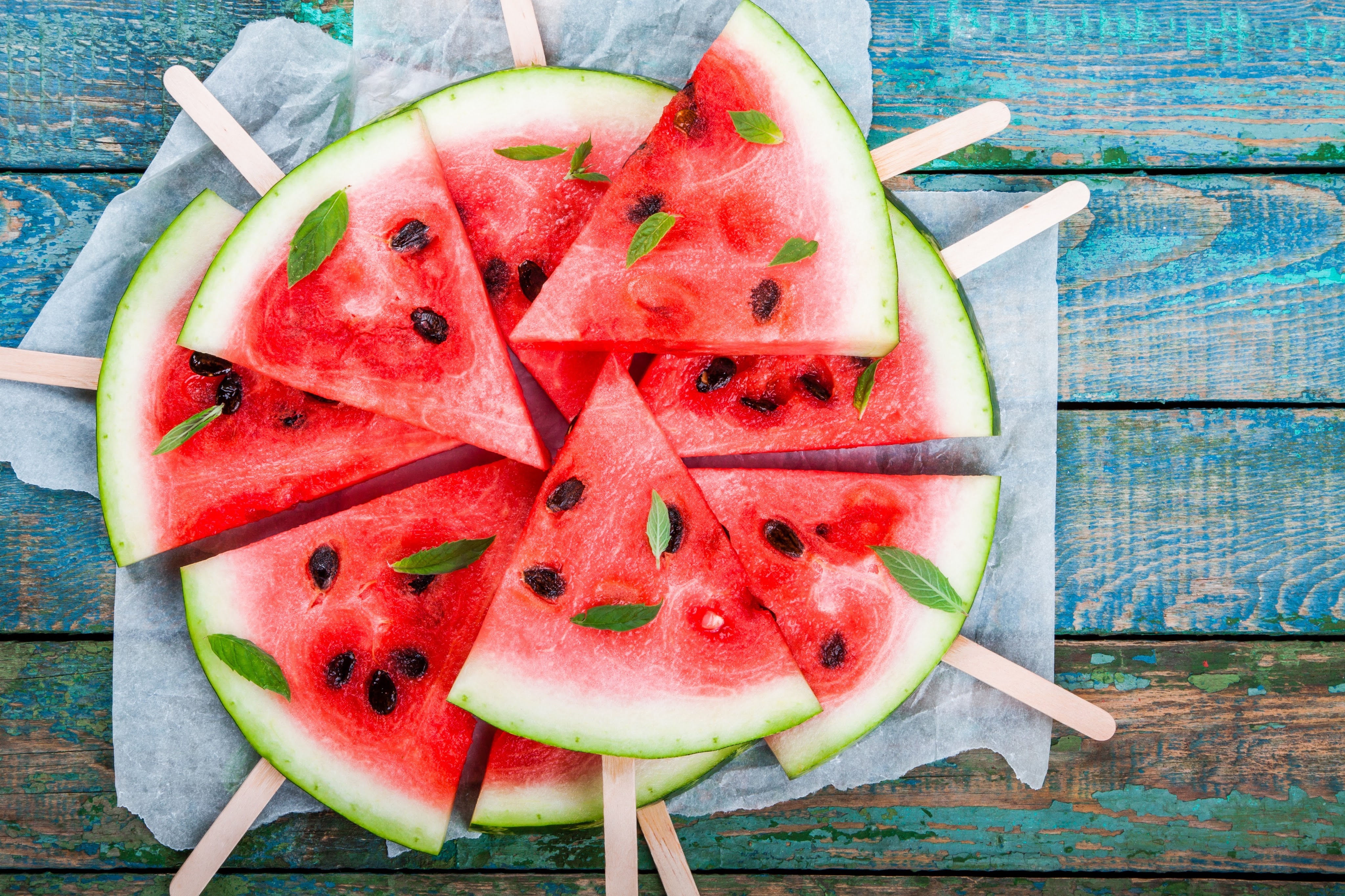 Popsicle sticks inserted into watermelon wedges for fun fruit appetizers