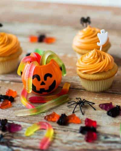 Decorating Halloween Cupcakes with Gummies - Colorful Treats Halloween cupcakes decorated with gummy candies, including gummy spiders, worms, and bats.