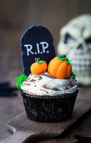 Halloween Cupcake with Edible Cookie Tombstone and Candy Pumpkins - Fun and Festive Decoration Halloween cupcake topped with an edible cookie tombstone and candy pumpkins.