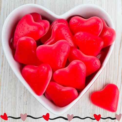 Enjoy Candy For Valentine's White heart shaped dish filled with Valentine candy.