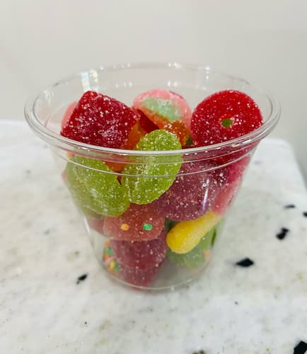 Individual Cups Is A Clear Winner For Serving Candy Salad Clear cup filled with a colorful assortment of candy salad.